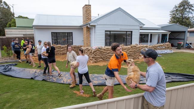 Members of the community work to prepare a home on the riverside of the newly built levee bank. Picture: Jason Edwards