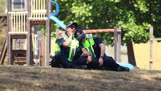 Two Tasmania Police officers console one another. Picture: Monte Bovill for ABC News
