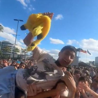 A fan crowd surfs.