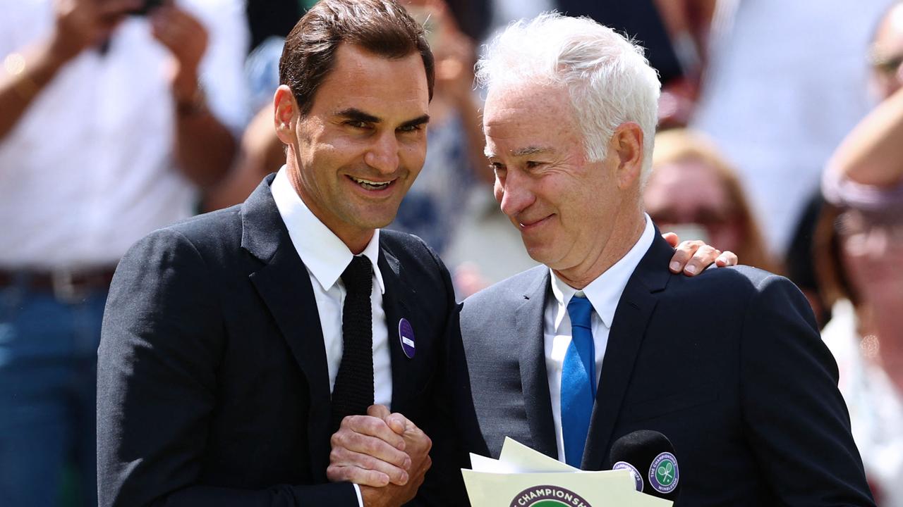 Federer with John McEnroe. Photo by Adrian DENNIS / AFP