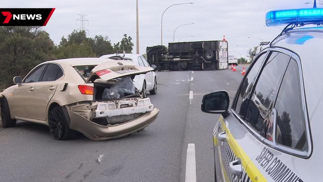 Two mates are lucky to be alive after a truck crashed into their car and rolled while they were trying to change a flat tyre. Picture: 7NEWS