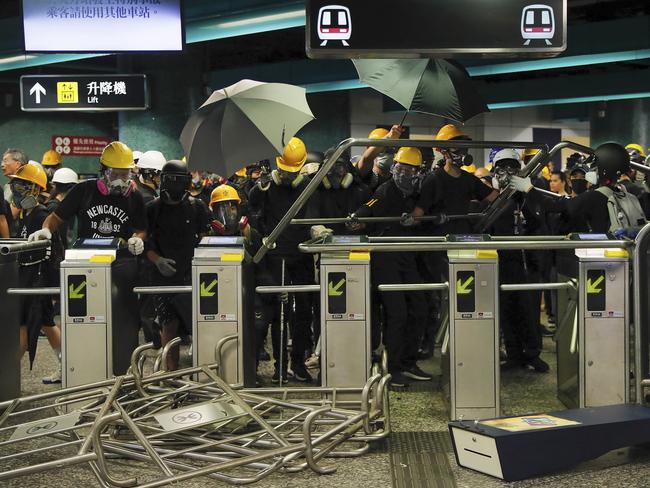 Protesters use steels barricades to form a defensive line inside the Quarry bay MTR station as they face with riot police in Hong Kong last Sunday. Picture: Getty