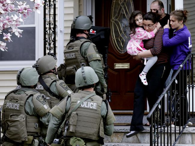 A woman carries a small child from a home in Watertown, Massachusetts as SWAT teams search for the Boston Marathon bombers. Picture: Charles Krupa/AP