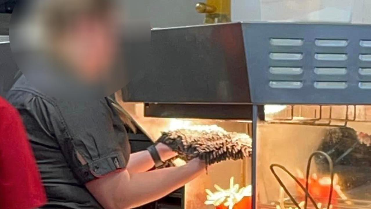 A McDonal'd worker appears to be drying a broom under a heat lamp in the fry station. Picture: Facebook