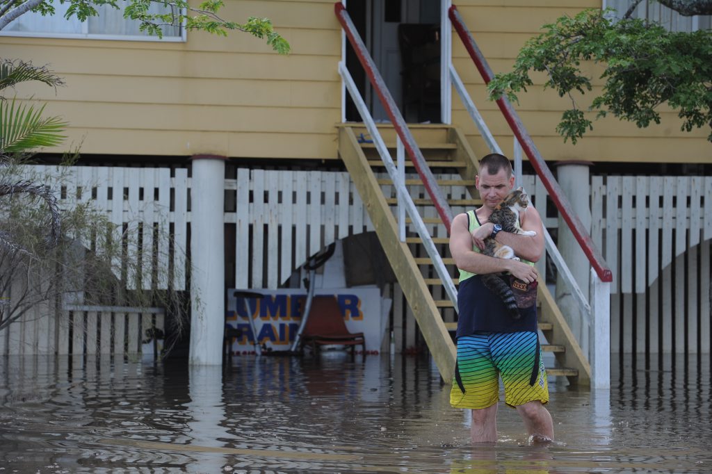 Mark Schulz with his cat Zipper wades through the water on his fathers property. Photo: Robyne Cuerel / Fraser Coast Chronicle. Picture: Robyne Cuerel