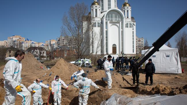 Members of the exhumation team work on a mass grave in Bucha as prosecutors begin investigating allegations of war crimes: Picture: Getty Images.