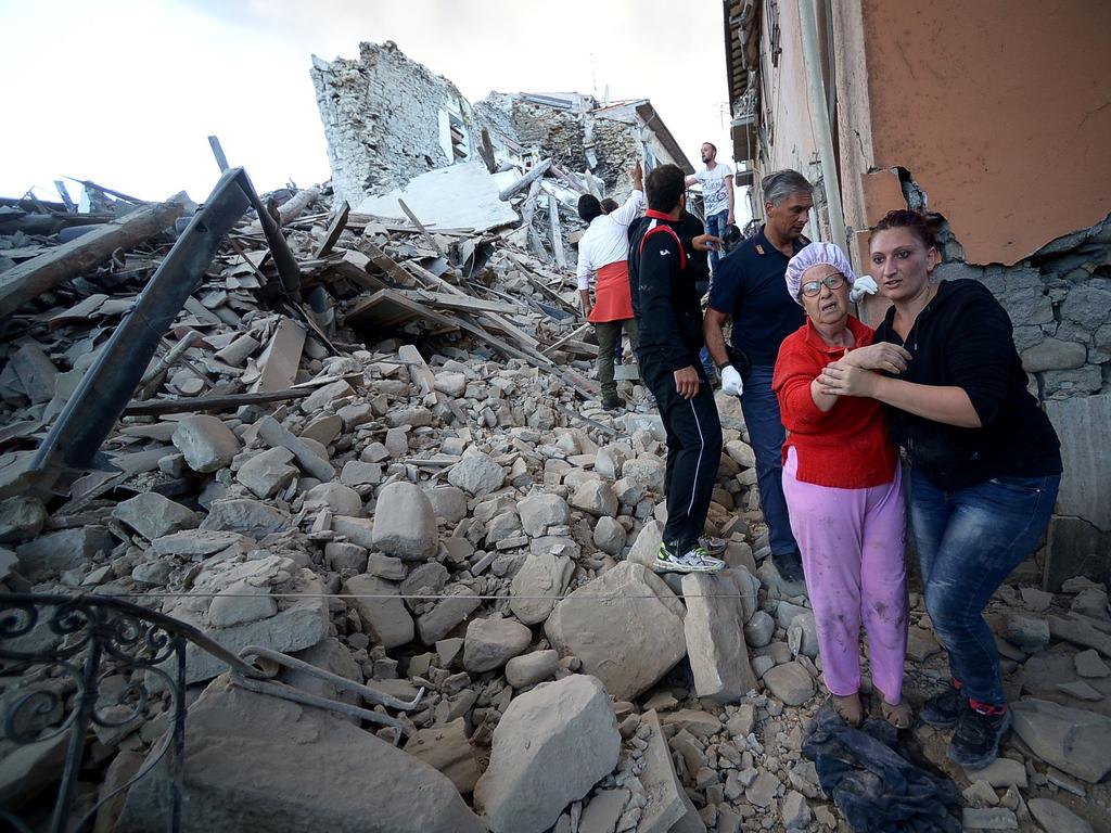 Devastated residents react among the rubble after a strong earthquake hit Amatrice on August 24, 2016. Picture: AFP