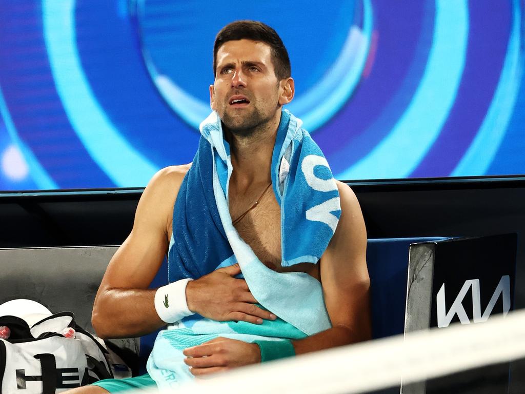 Novak Djokovic holds his midsection during a break in his match against Milos Raonic. (Photo by Cameron Spencer/Getty Images)