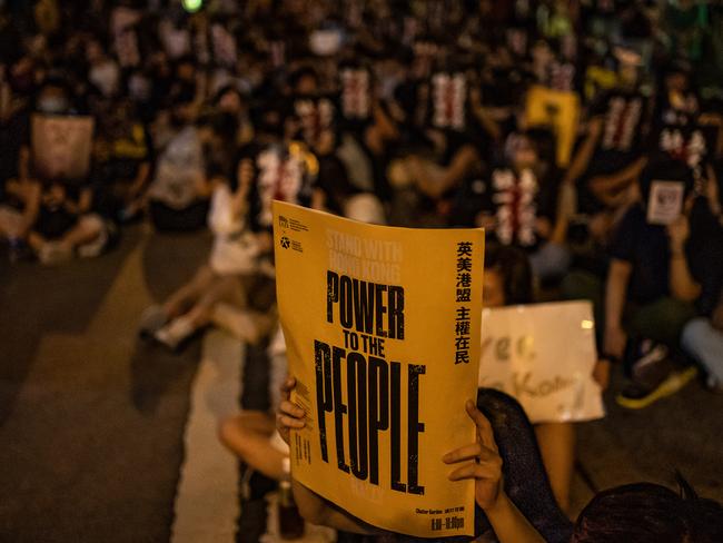 Protesters hold placards during a rally in Chartered Garden, Hong Kong. Picture: Getty Images