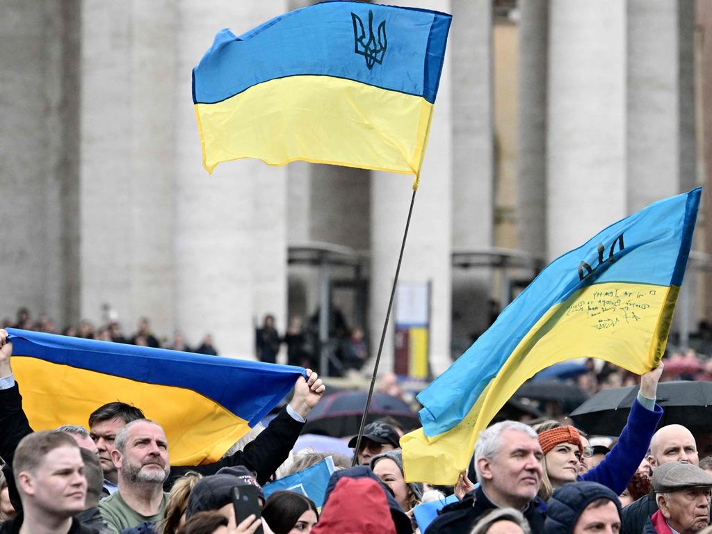 People wave Ukrainian flags at St. Peter's square as Pope Francis addresses the crowd during his Sunday Angelus prayer on March 10, 2024 at the Vatican. Picture: AFP