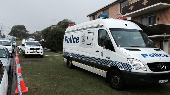 Police vans block the entrance to the apartment building at the corner of Foam St and Wyadra Ave, Freshwater.