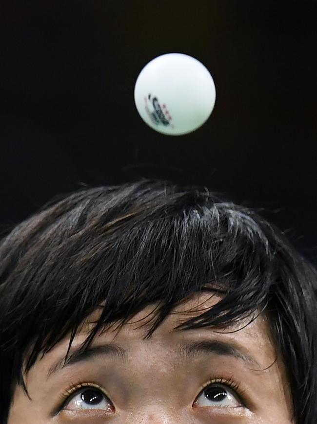 North Korea's Kim Song I eyes the ball as she serves against Japan's Ai Fukuhara in their women's singles bronze medal table tennis match at the Riocentro venue during the Rio 2016 Olympic Games in Rio de Janeiro on August 10, 2016. / AFP PHOTO / Jim WATSON