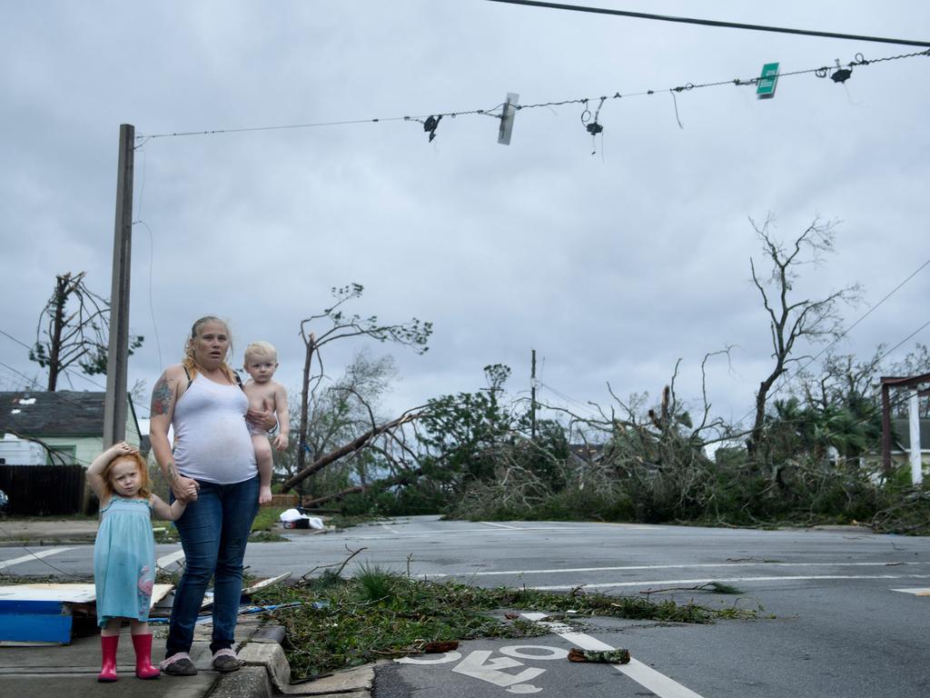 A woman and her children wain near a destroyed gas station after Hurricane Michael in Panama City, Florida. Picture: AFP