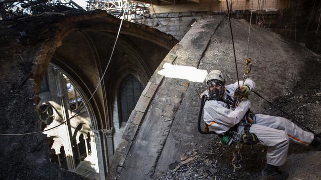 A rope access technician inside the ruined cathedral.