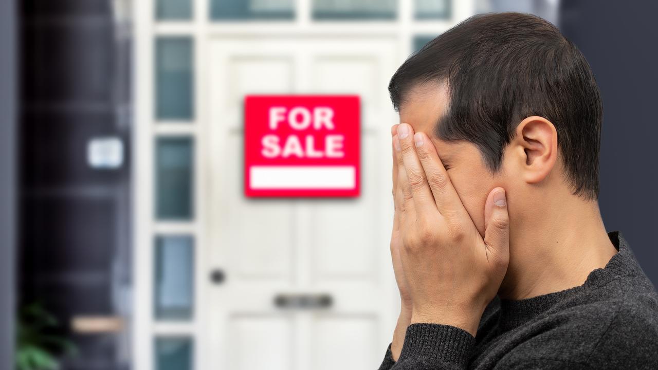 Man extremely depressed and sad about losing his house key and seeing a for sale sign, real estate concept; first home buyer generic sad, stressed