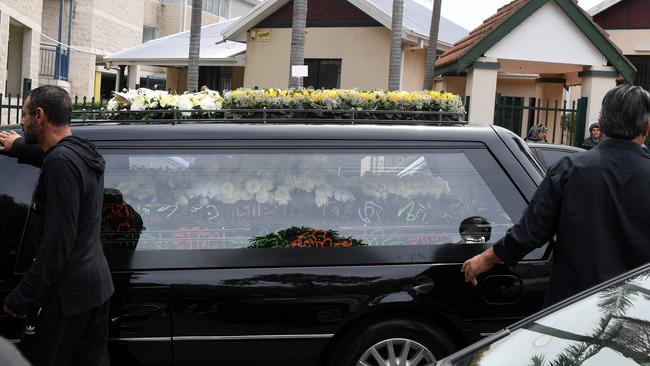 Attendants walk along the hearse carrying the coffin of Mick Hawi's at an Arncliffe mosque.