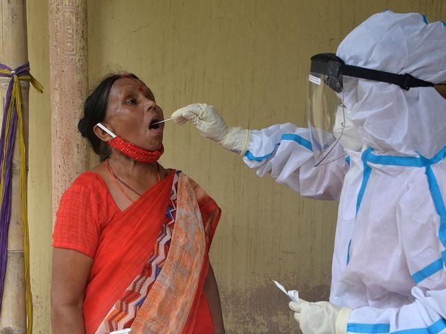 A health worker collects a swab sample from a woman to test for Covid-19 as India passed more than 300,000 deaths from the coronavirus pandemic. Picture: AFP