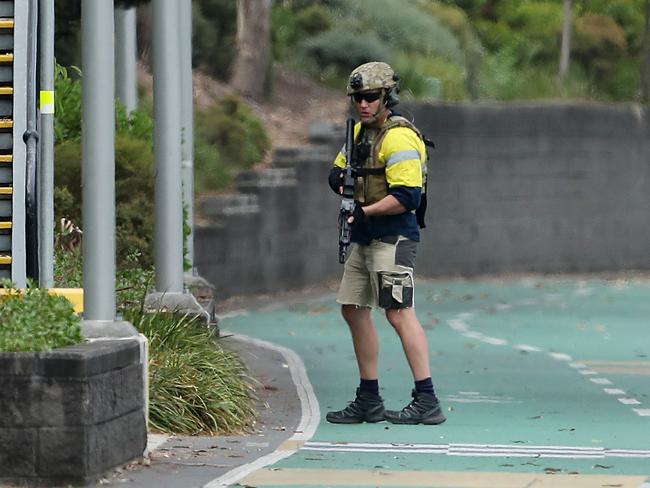 A SERT officer with machine gun stands guard. Photographer: Liam Kidston.