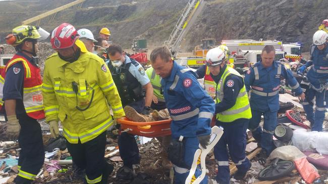 One man is dead and another injured after they were trapped by tonnes of rubbish.