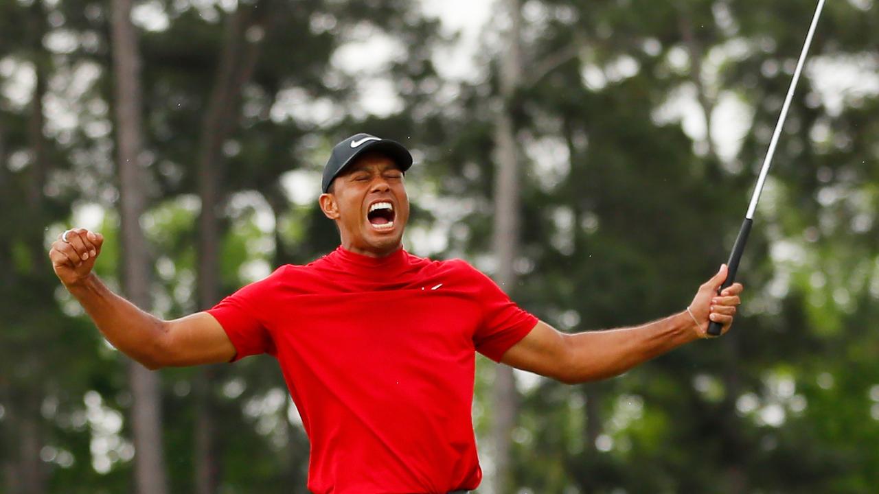 AUGUSTA, GEORGIA - APRIL 14: Tiger Woods of the United States celebrates after sinking his putt on the 18th green to win during the