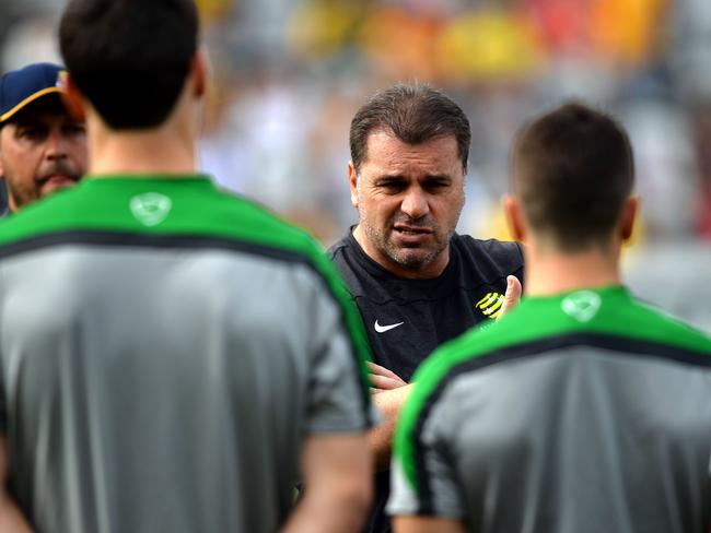 Australia's 'Socceroos' national football head coach Ange Postecoglou (C) talks to his players during the team's training session at the Central Coast Stadium in Gosford on May 18, 2014. IMAGE RESTRICTED TO EDITORIAL USE - STRICTLY NO COMMERCIAL USE -- AFP PHOTO / SAEED KHAN