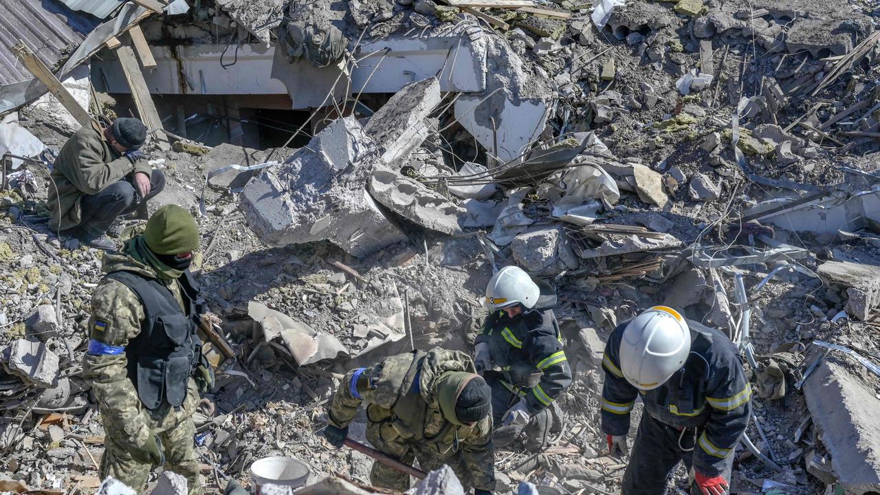 Ukrainian soldiers and rescue officers search for bodies in the debris. Picture: Bulent Kilic/AFP