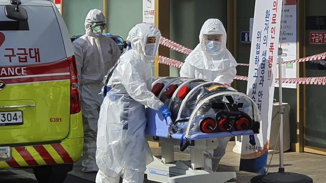 Medical workers move a patient suspected of contracting coronavirus from an ambulance to the Kyungpook National University Hospital in South Korea Picture: Kim Jong-un/Yonhap via AP