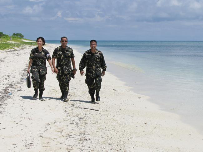  Philippine Army troops take a leisurely walk along the white sand beach of Thitu (Pag-asa). Picture: AP