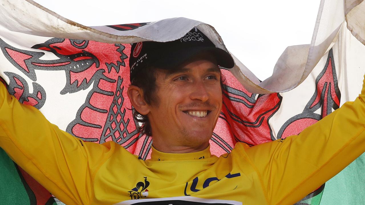 Tour de France winner Britain's Geraint Thomas, wearing the overall leader's yellow jersey, celebrates with the flag of Wales on the podium after the twenty-first stage of the Tour de France cycling race over 116 kilometers (72.1 miles) with start in Houilles and finish on Champs-Elysees avenue in Paris, France, Sunday July 29, 2018. (AP Photo/Christophe Ena )