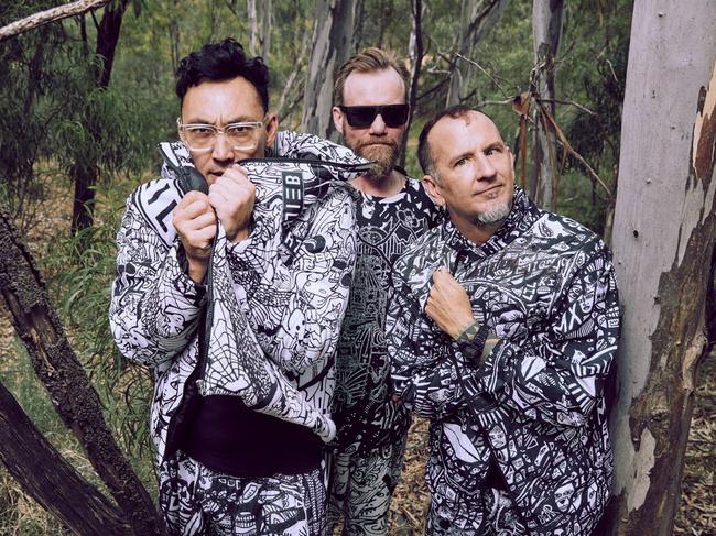 ***EXCLUSIVE FOR THE AUSTRALIAN ONLY***Australian alternative rock band Regurgitator, whose 10th album 'Invader' was released in 2024. Outfits designed by Lewis Beilharz. L-R: Quan Yeomans (guitar/vocals), Peter Kostic (drums) and Ben Ely (bass/vocals). Picture: Neil Prieto