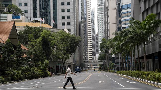 A man crosses a deserted street in the Singapore central business district. Picture: Getty Images