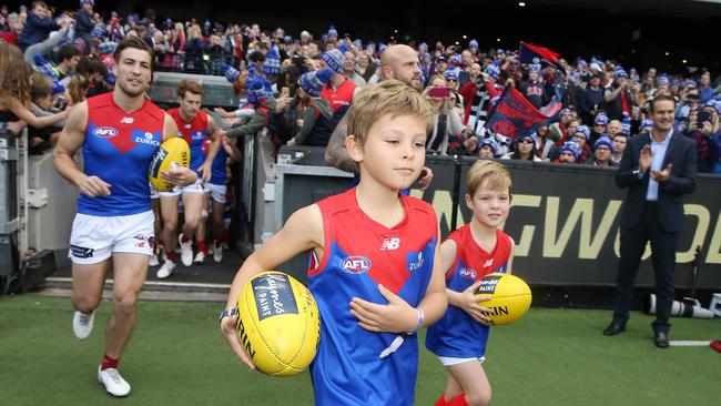 Oliver and Wilba Green, sons of ex Melbourne captain Brad Green lead the demons onto the MCG in honour of their mother Anna. Picture: Michael Klein