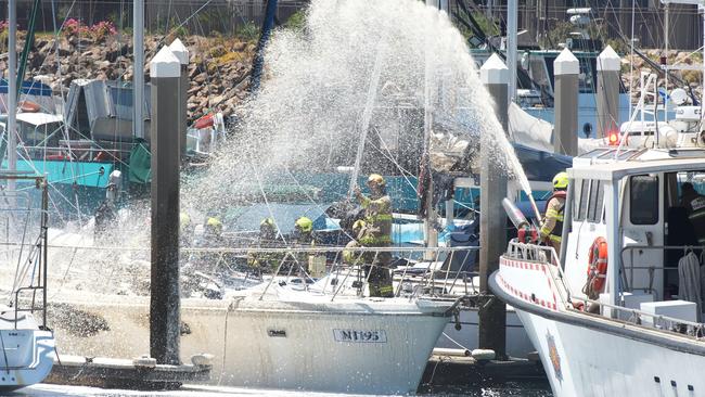 A yacht destroyed by fire while moored near the Sail Master Tavern at North Haven. With the fire almost extinguished, more water is sprayed onto the burnt out hull. 1 February 2025. Picture: Dean Martin