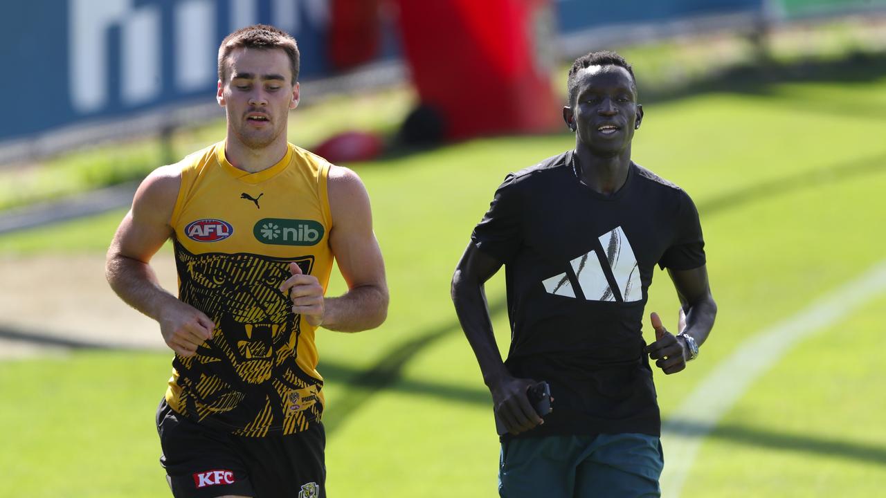 Tiger Seth Campbell runs laps with Australian 800m runner Peter Bol. Picture: David Crosling