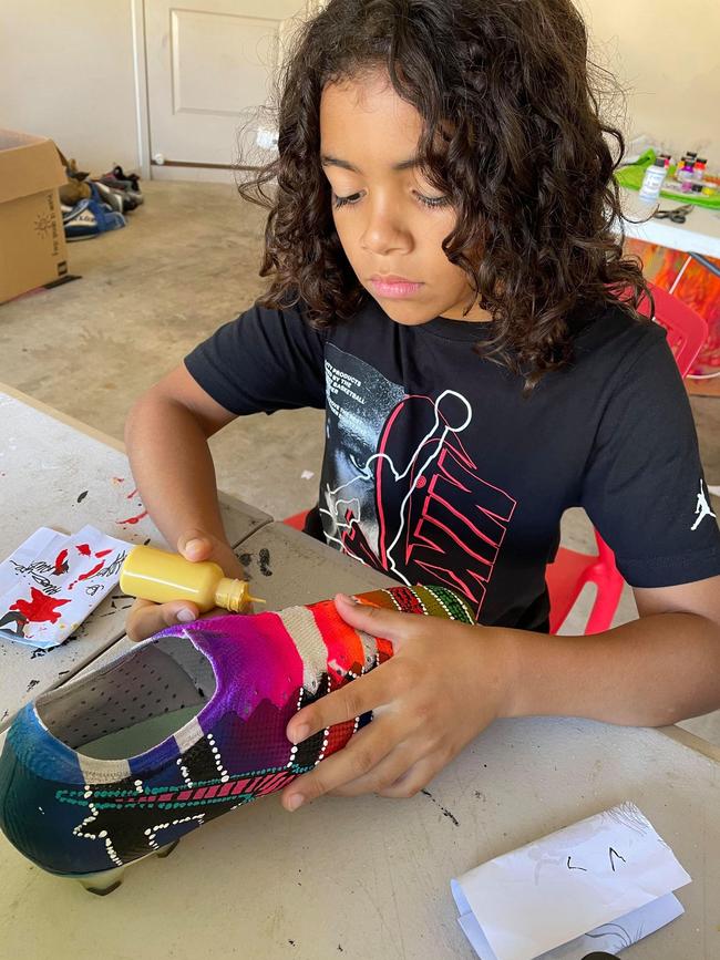 Lennox Monaghan works on his custom-designed footy boots which will be worn by a South Sydney Rabbitohs player. Photo: Bianca Monaghan