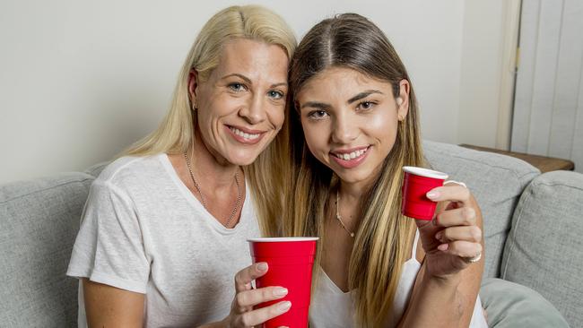 Jenevieve Dooley (Olivia's mother) holding a normal cup (left) and Olivia holding the cup she has to use to slow her water intake down for her kidney to function properly. Picture: Jerad Williams