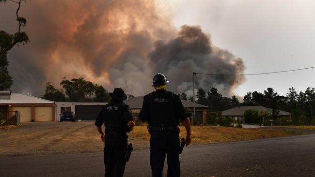 NSW Police watch as the Green Wattle Creek Fire threatens homes south west of Sydney last month. Picture: AAP