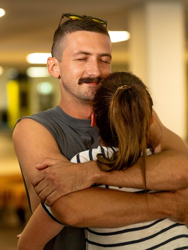 Darwin received its first arrivals from interstate as further border restrictions are lifted. James Barnham and Brittni Barwick hug as they are reunited. Picture: Che Chorley