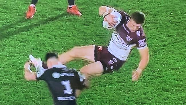 Manly’s Reuben Garrick is tackled in mid-air by NZ Warriors fullback Charnze Nikoll-Klokstad in Auckland last night.