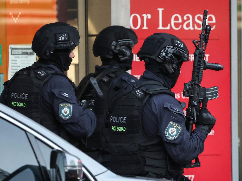 Heavily-armed police enter the Westfield Bondi Junction. Picture: David GRAY / AFP