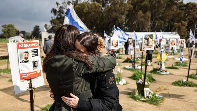 Two women react while visiting the site of the Supernova music festival near Kibbutz Reim, southern Israel.