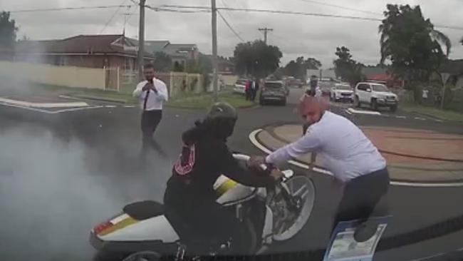 A man is pictured in the video helping a motorbike rider begin a burnout. Picture: Facebook/Dash Cam Owners Australia