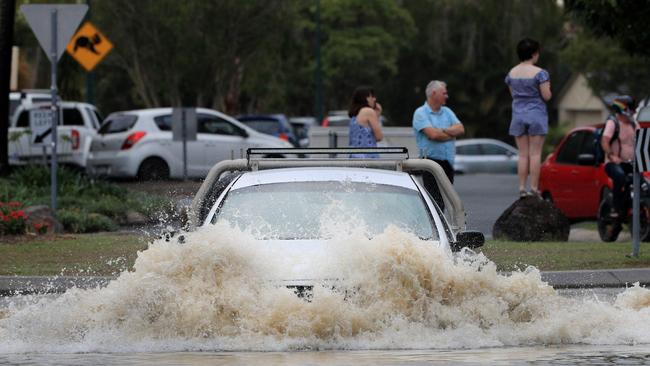 Drivers ignore Flood warnings to drive through heavy flood water after the Tallebudgera Creek burst its banks at the western end of 19th Avenue, Elanora. Photo: Scott Powick.