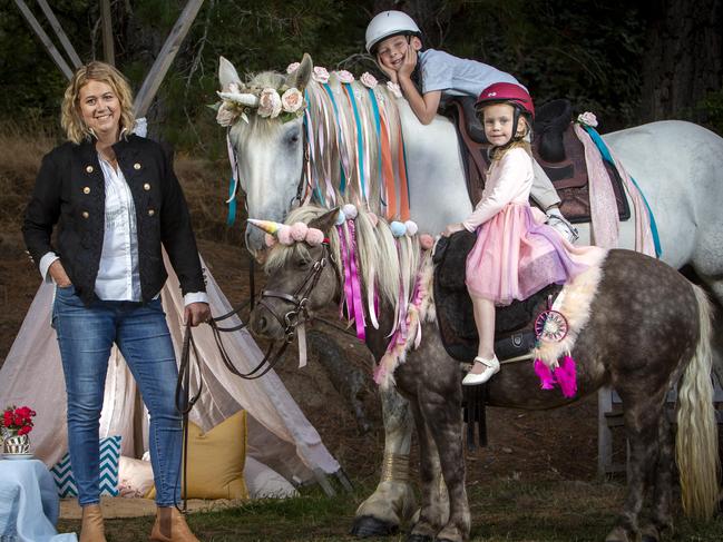 ADELAIDE, AUSTRALIA - Advertiser Photos FEBRUARY 17, 2022: Libby Green Owner of Unicorns at Classic Carriage Drives holds her two Unicorns Indiana (white horse) ridden by Hudson Weller 7yrs while his little sister Grace Weller 4yrs rides unicorn Mabel (brown pony) in Montacute, SA. Picture Emma Brasier