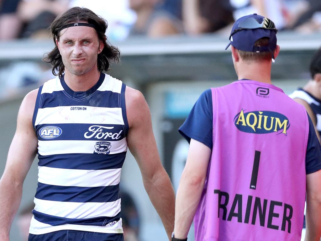 Henry is assessed by a Geelong trainer after his footy injury. (Photo by Kelly Defina/Getty Images)