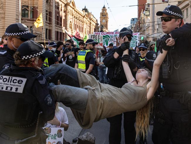 MELBOURNE, AUSTRALIA - NCA NewsWire Photos - 16 MARCH 2024: Extinction Rebellion activists get arrested by members of Victoria Police as they blocked the Flinders Street Station intersection Picture: NCA NewsWire / Diego Fedele