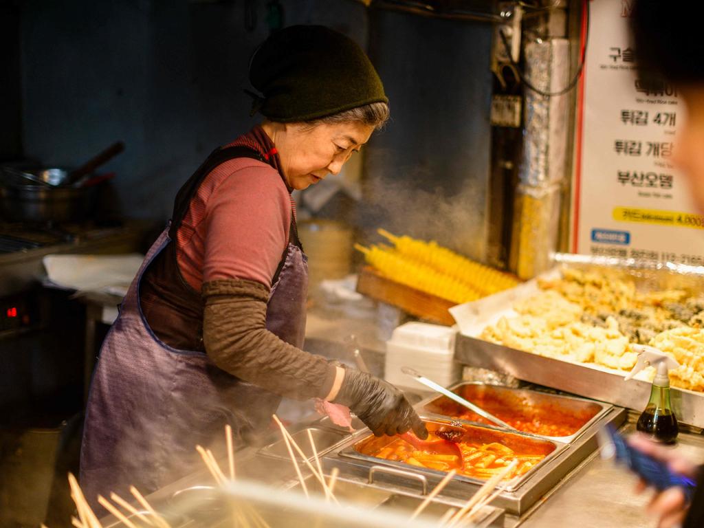 A street food vendor prepares tteokbokki, or simmered rice cake, for customers in Busan, South Korea.