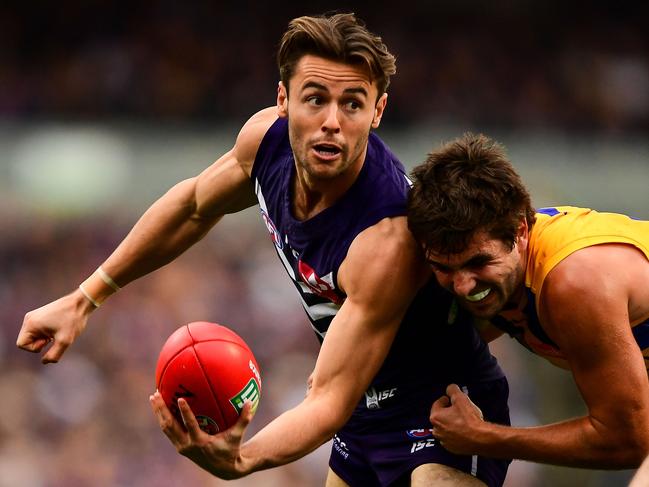 PERTH, AUSTRALIA - JULY 16: Lachie Weller of the Dockers handpasses the ball under pressure from Andrew Gaff of the Eagles during the 2017 AFL round 17 match between the Fremantle Dockers and the West Coast Eagles at Domain Stadium on July 16, 2017 in Perth, Australia. (Photo by Daniel Carson/AFL Media/Getty Images)