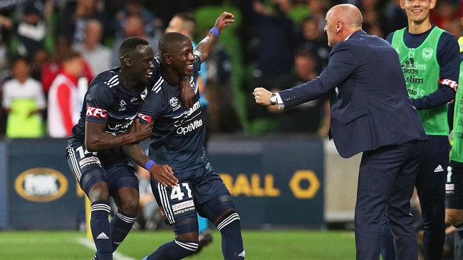 Leroy George (C) celebrates his goal with Melbourne Victory Head Coach Kevin Muscat (R).