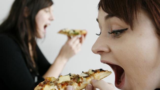 Bethany Smith (21yrs) and Shallene Rigby (22yrs, lighter shorter hair) of Kelvin Grove chow down on pizza despite increasing prices